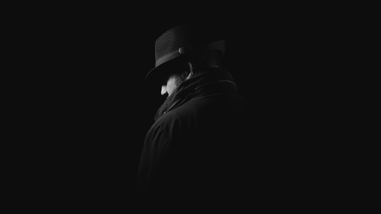 Spion Detektiv über das Arbeiten in einer Detektei Mann schwarzer Hut Mantel mysteriös